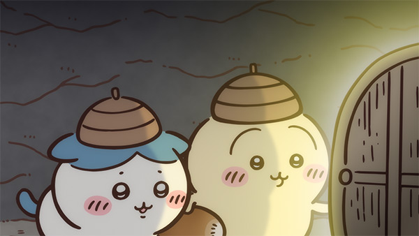 うす暗い岩のトンネルの中で、どんぐりの殻のような帽子をかぶった二人が並んで立っている。右手前には明かりの灯った木の扉がある。アニメ「ちいかわ」第320話「うさぎの家②」の場面